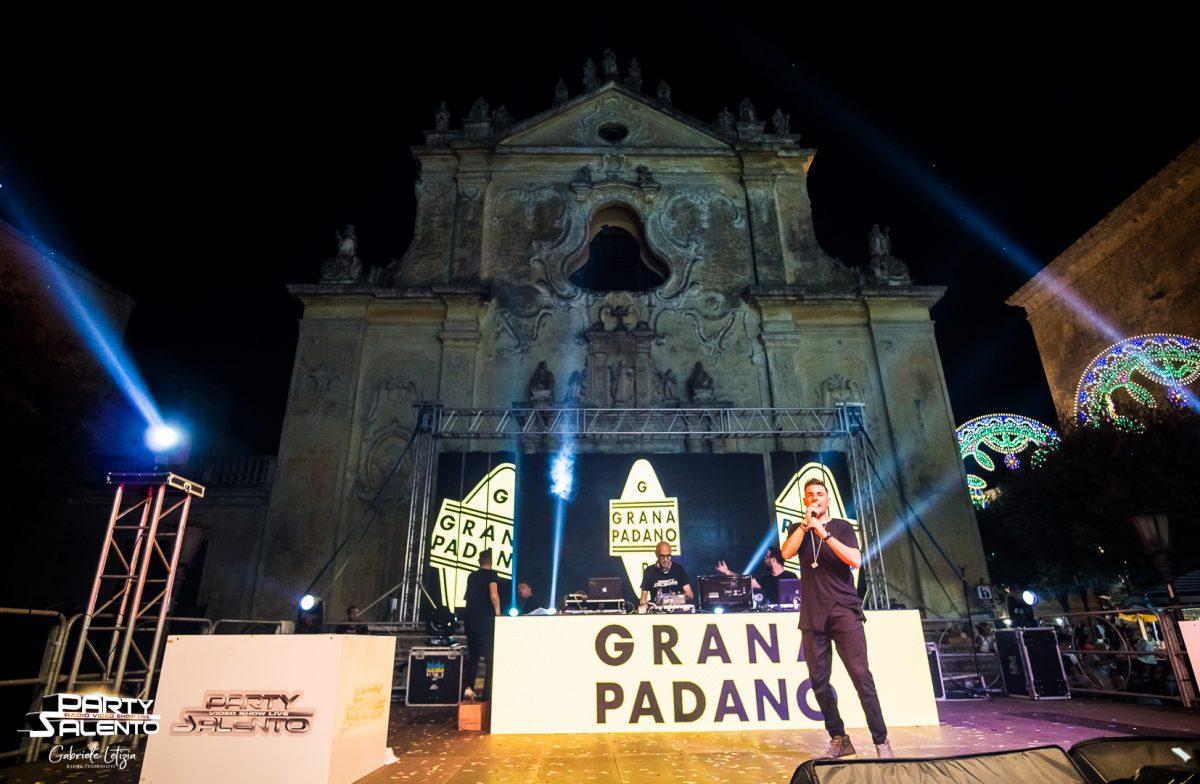 Palco in piazza davanti a una facciata barocca, con fasci di luce