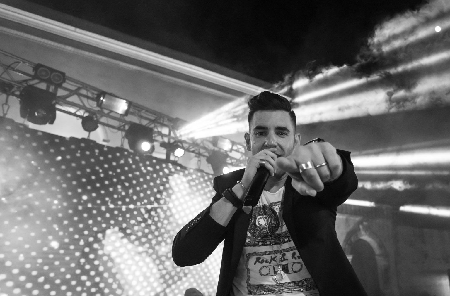 Massimo Manca sul palco, microfono in mano, tra le luci di scena